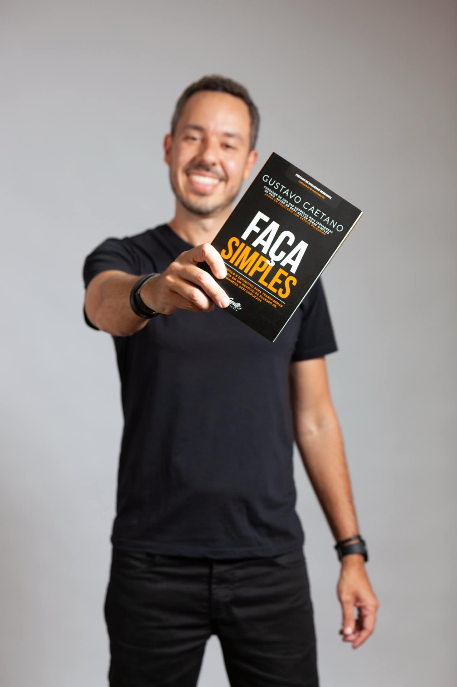 Gustavo Caetano apontando para o livro Faça Simples