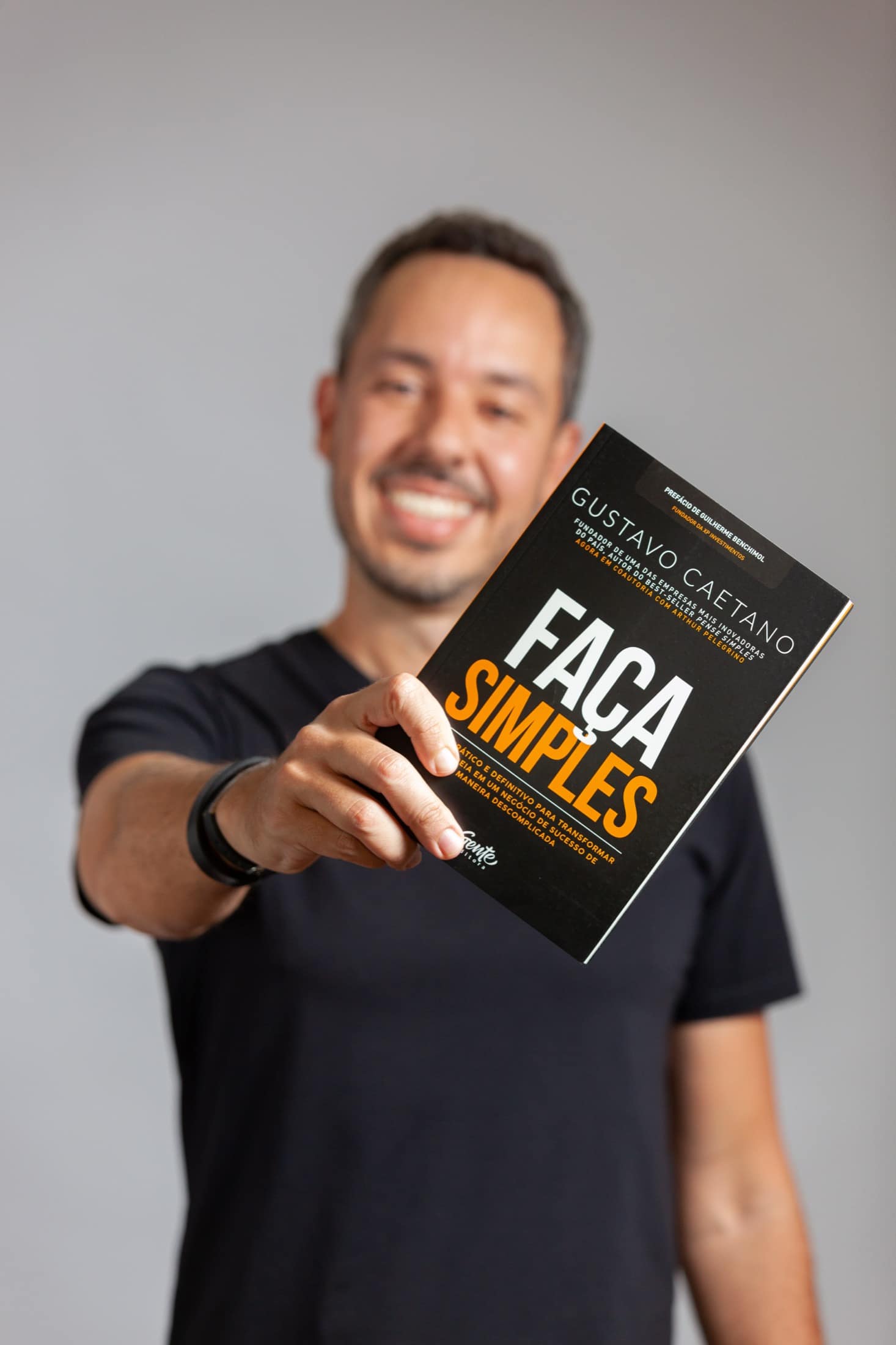 Gustavo Caetano olhando o livro Faça Simples